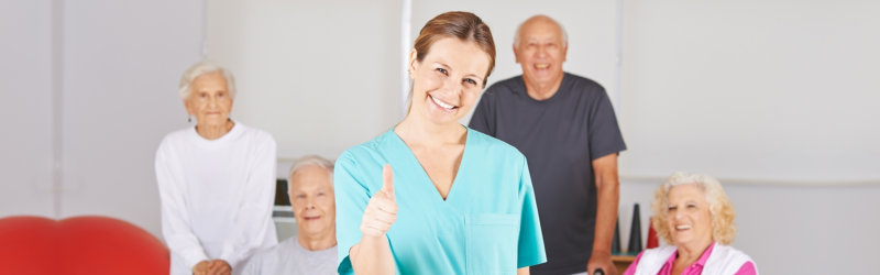 community of elderly with their caregiver smiling