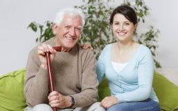 caregiver and senior man smiling